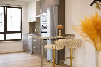 a kitchen with a stainless steel refrigerator and two bar stools at GemAn1 in Monforte de Lemos