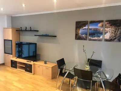 a living room with a glass table and a television at Golfiños in Carballino