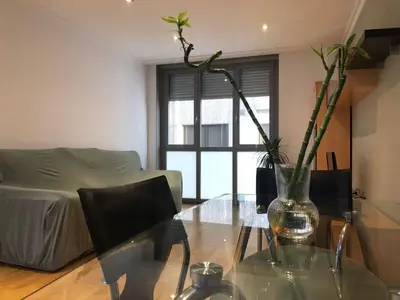 a living room with a glass table with a vase with flowers at Golfiños in Carballino