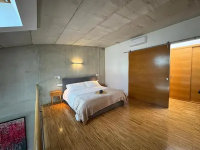 a bedroom with a bed and a wooden floor at Loft Experience in Amés
