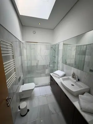 a white bathroom with a sink and a toilet at Loft Experience in Amés