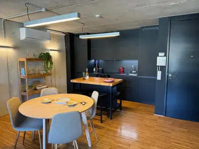a kitchen with a table and chairs and a kitchen with a counter at Loft Experience in Amés