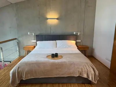 a bedroom with a bed with two black mugs on it at Loft Experience in Amés