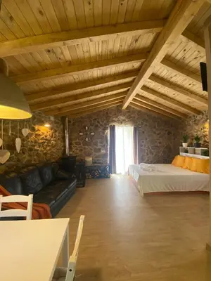 a living room with a bed and a couch at Casa de Piedra Vistas & Relax