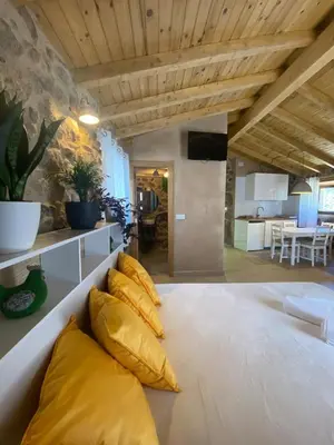 a living room with a white couch with yellow pillows at Casa de Piedra Vistas & Relax