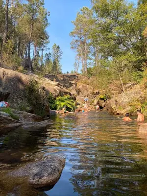 a group of people swimming in a river at Casa de Piedra Vistas & Relax