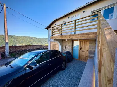 a car parked in front of a house at Wine Lodge Ribeira Sacra in Carracedo