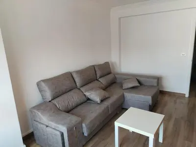 a living room with a brown couch and a table at Apartamento en Carballiño in Carballino