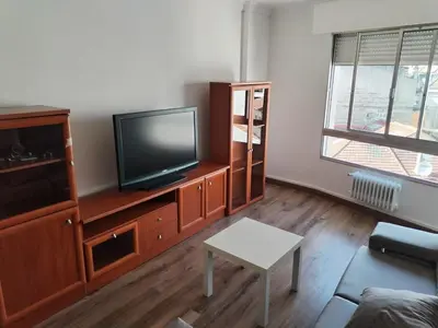 a living room with a flat screen tv on a wooden cabinet at Apartamento en Carballiño in Carballino
