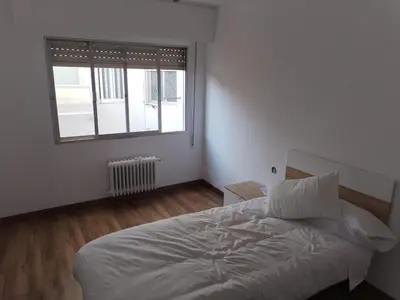 a white bedroom with a bed and a window at Apartamento en Carballiño in Carballino