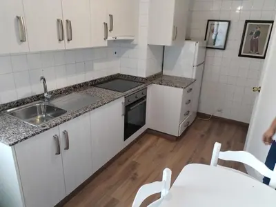 a small kitchen with white cabinets and a sink at Apartamento en Carballiño in Carballino