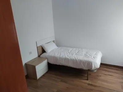 a small bedroom with a bed and a night stand at Apartamento en Carballiño in Carballino