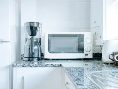 a kitchen with a blender and a microwave at Aida's Apartments in Puentes de García Rodríguez
