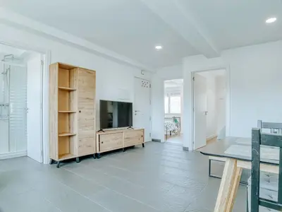 a living room with a tv and a table at Aida's Apartments in Puentes de García Rodríguez