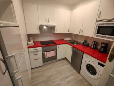 a small kitchen with white cabinets and red counter tops at Rua Nova Apartment 28, 3 Dormitorios, WIFI, PS4 y Netflix, a 200m Catedral in Santiago de Compostela