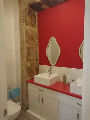 a bathroom with a sink and a red wall at Rua Nova Apartment 28, 3 Dormitorios, WIFI, PS4 y Netflix, a 200m Catedral in Santiago de Compostela