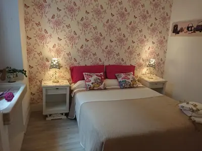 a small bedroom with a bed and two night stands at Rua Nova Apartment 28, 3 Dormitorios, WIFI, PS4 y Netflix, a 200m Catedral in Santiago de Compostela