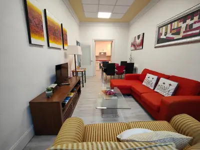 a living room with a red couch and a table at Rua Nova Apartment 28, 3 Dormitorios, WIFI, PS4 y Netflix, a 200m Catedral in Santiago de Compostela