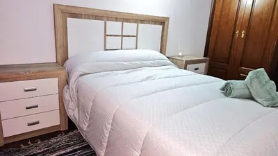 a bedroom with a bed and a dresser and a window at Garcia Prieto Vivienda in Santiago de Compostela