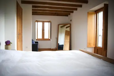 a bedroom with a white bed and two windows at Casa Xabú in El Vallin