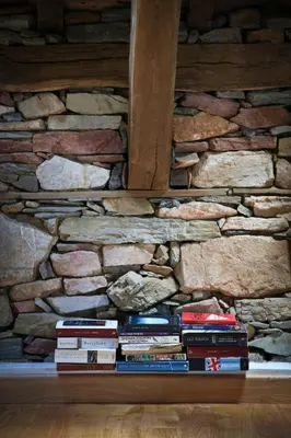 a stack of books in front of a stone wall at Casa Xabú in El Vallin