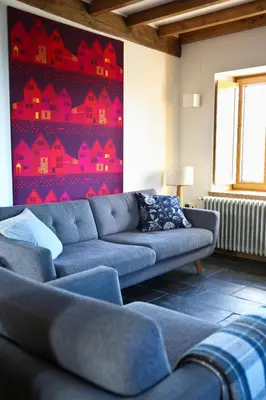 a living room with a blue couch and a red wall at Casa Xabú in El Vallin