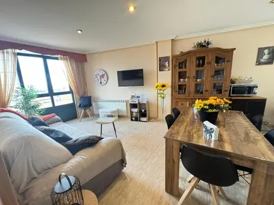 a living room with a couch and a table at Amanecer en Playa de LLás in Foz