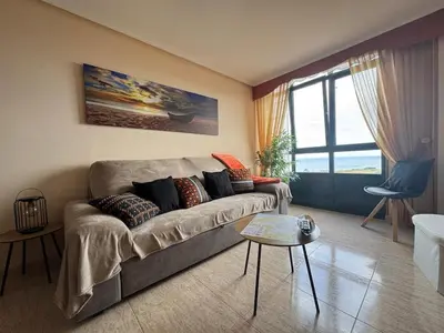 a living room with a couch and a table at Amanecer en Playa de LLás in Foz
