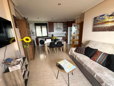a living room with a couch and a table at Amanecer en Playa de LLás in Foz