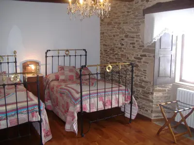 a bedroom with two beds and a brick wall at Casa Grande de Anllo in Sistallo