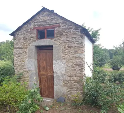 a small stone building with a wooden door at Casa Grande de Anllo in Sistallo