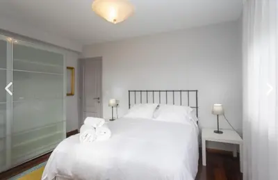 a bedroom with a white bed with towels on it at apartamento 1 matrimonial con terraza acristalada in Tapia de Casariego