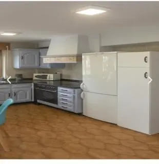 a kitchen with white appliances and a white refrigerator at apartamento 1 matrimonial con terraza acristalada in Tapia de Casariego