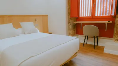 a desk with a chair next to a window at Hotel Recanto do Avia in Ribadavia