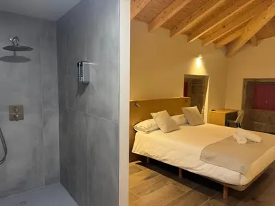a bedroom with a large white bed and a tv at Hotel Recanto do Avia in Ribadavia