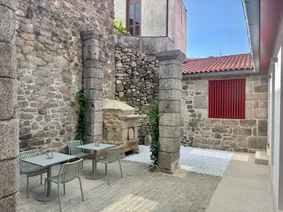 a bedroom with a bed and a desk and a television at Hotel Recanto do Avia in Ribadavia