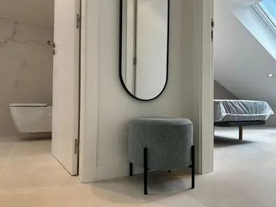 a bathroom with a chair and a mirror at Apartamento Lujo Casco Histórico in Santiago de Compostela