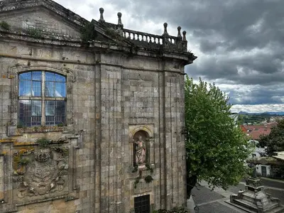 an old building with a statue on the side of it at Apartamento Lujo Casco Histórico in Santiago de Compostela