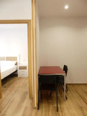 a small room with a table and a bed at Monqar Leandro in Foz