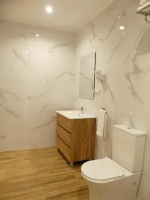 a white bathroom with a toilet and a sink at Monqar Leandro in Foz