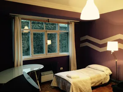a bedroom with a bed and a table and a window at Apartment Lugo Rooms in Lugo