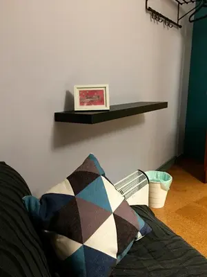 a shelf on a wall with a pillow on a couch at Apartment Lugo Rooms in Lugo