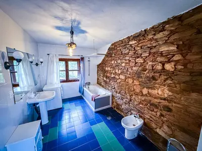 a bathroom with two sinks and a stone wall at La Casa del Monte in Ocero