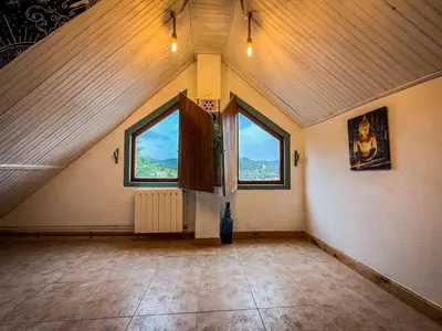 a large room with two windows in a attic at La Casa del Monte in Ocero