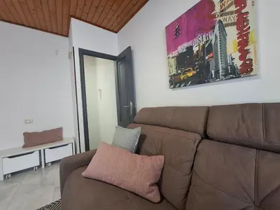 a living room with a brown leather couch at O Enxido - Vive dentro de la muralla de Ribadavia in Ribadavia
