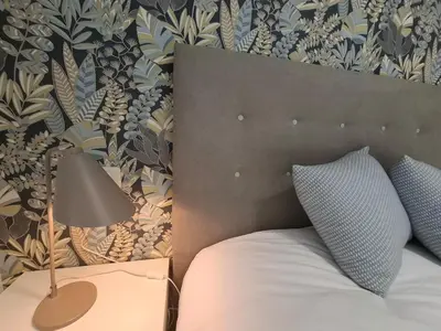 a bedroom with a bed and a lamp and a wall at O Enxido - Vive dentro de la muralla de Ribadavia in Ribadavia