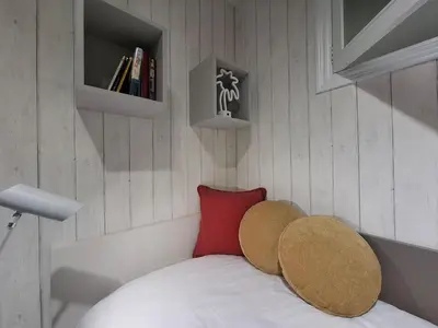 a small room with a bed with a red pillow at O Enxido - Vive dentro de la muralla de Ribadavia in Ribadavia