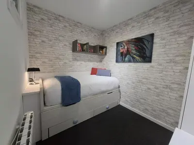 a bedroom with a bed and a brick wall at O Enxido - Vive dentro de la muralla de Ribadavia in Ribadavia