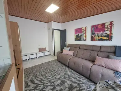 a living room with a brown couch in a room at O Enxido - Vive dentro de la muralla de Ribadavia in Ribadavia