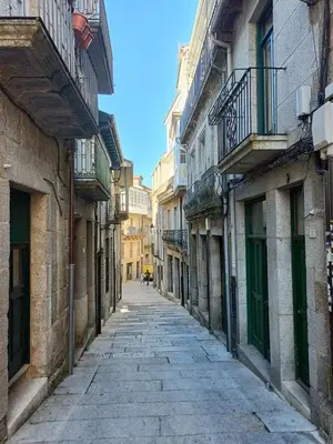 an empty street in an alley with buildings at O Enxido - Vive dentro de la muralla de Ribadavia in Ribadavia
